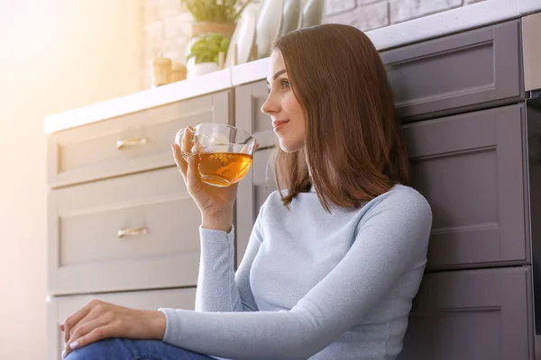 Hermosa joven bebiendo té en la cocina — Foto de Stock