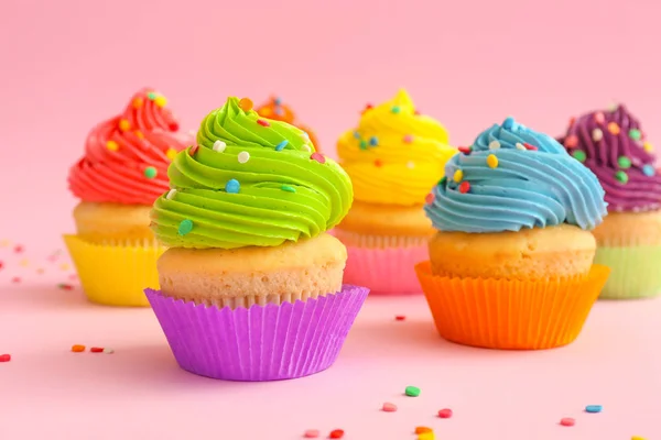 Doces cupcakes saborosos no fundo da cor — Fotografia de Stock