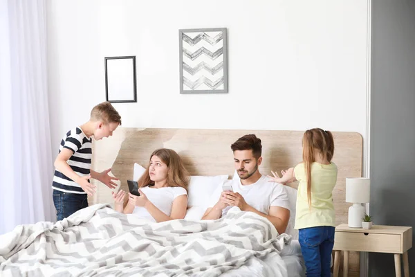 Děti Odbarvující rodiče závislostí na moderních technologiích v ložnici — Stock fotografie