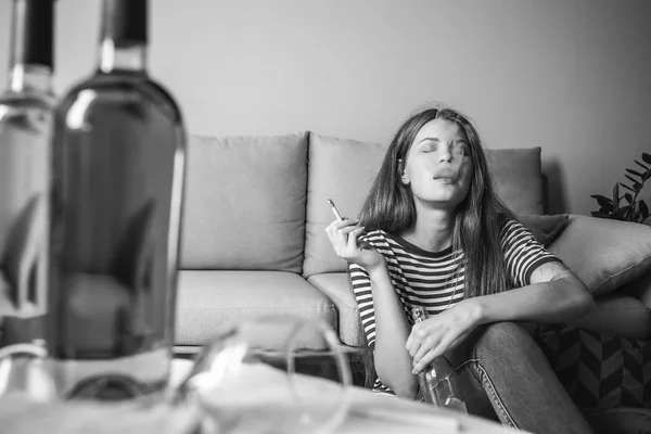 Jovem com dependência de álcool e cigarros relaxando em casa — Fotografia de Stock