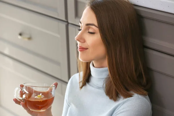 Bella giovane donna che beve tè in cucina — Foto Stock