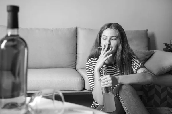 Молода жінка з залежністю від алкоголю та сигарет, що розслабляються вдома — стокове фото