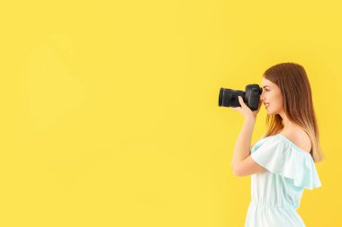 Renkli arka planda genç kadın fotoğrafçı