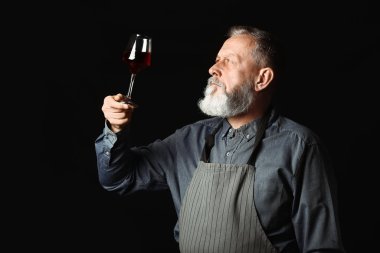 Koyu arka plan üzerinde olgun sommelier portresi