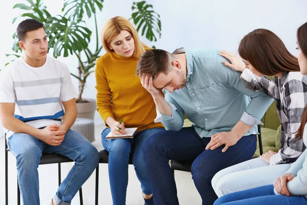 People calming man at group therapy session — Stock Photo, Image