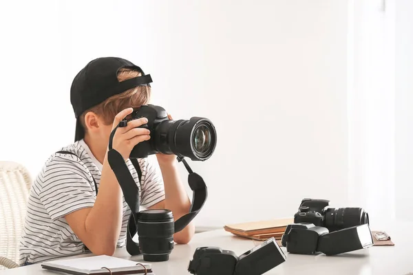 Roztomilý malý fotograf s profesionální kamerou doma — Stock fotografie