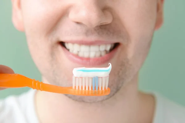 Man with toothbrush on color background, closeup. Concept of dental hygiene — Stock Photo, Image