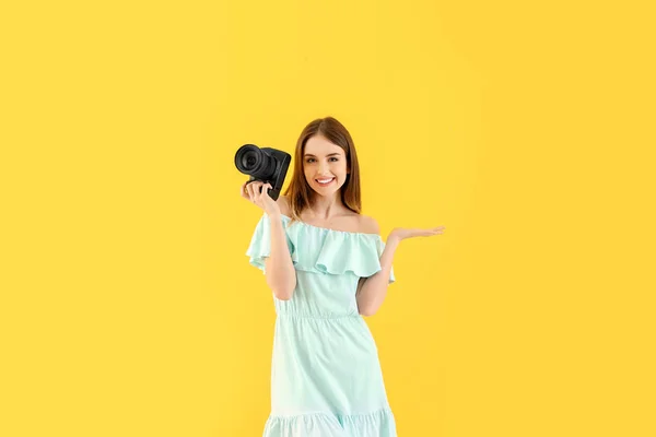 Young female photographer on color background — Stock Photo, Image