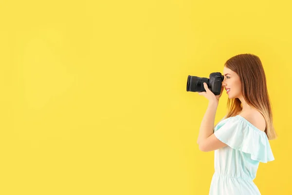 Молодая женщина фотограф на цветном фоне — стоковое фото