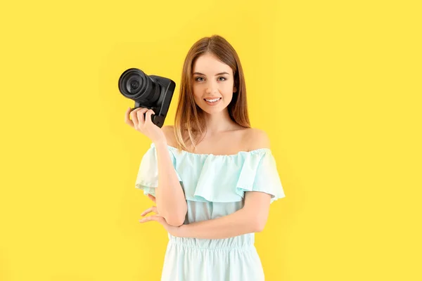 Jonge vrouwelijke fotograaf op kleur achtergrond — Stockfoto