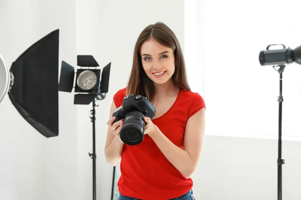 Jonge vrouwelijke fotograaf in studio — Stockfoto