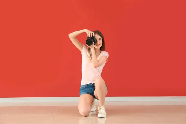 Jovem fotógrafa contra parede colorida — Fotografia de Stock