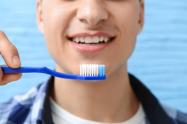 Handsome man with toothbrush on color background, closeup — Stock Photo, Image