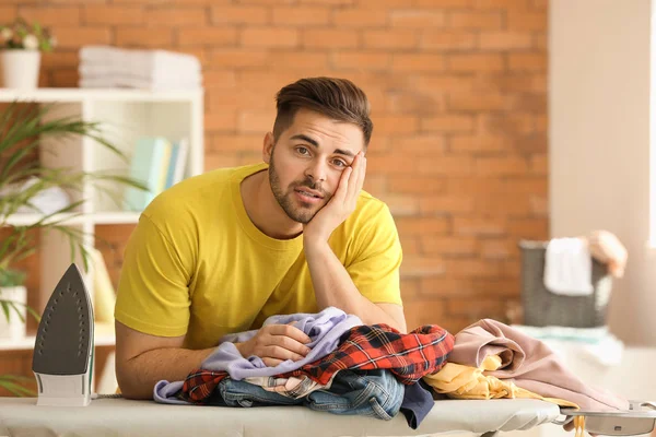 Ledsen ung man ovillig att järnkläder hemma — Stockfoto