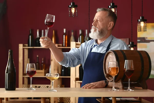 Mature sommelier working in wine cellar — Stock Photo, Image