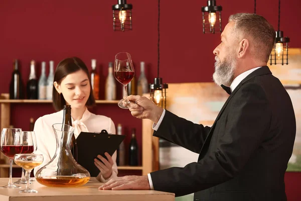 Mature sommelier with his student in wine cellar — Stock Photo, Image