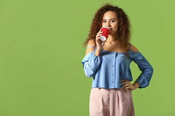 Όμορφη νεαρή γυναίκα με φλιτζάνι καφέ στο φόντο χρώμα — Φωτογραφία Αρχείου