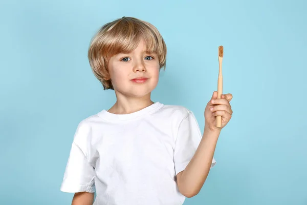 Carino piccolo ragazzo spazzolatura denti su colore sfondo — Foto Stock