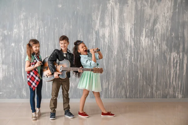 Band der kleinen Musiker gegen Grunge-Wand — Stockfoto