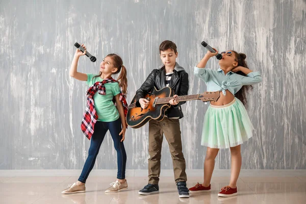 Группа маленьких музыкантов против гранж-стены — стоковое фото