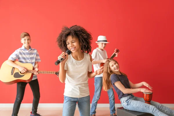 Músicos adolescentes jugando contra la pared de color —  Fotos de Stock