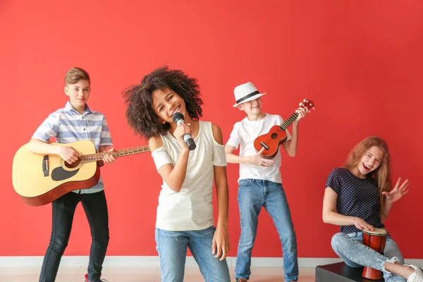 Musicisti adolescenti che suonano contro la parete a colori — Foto Stock