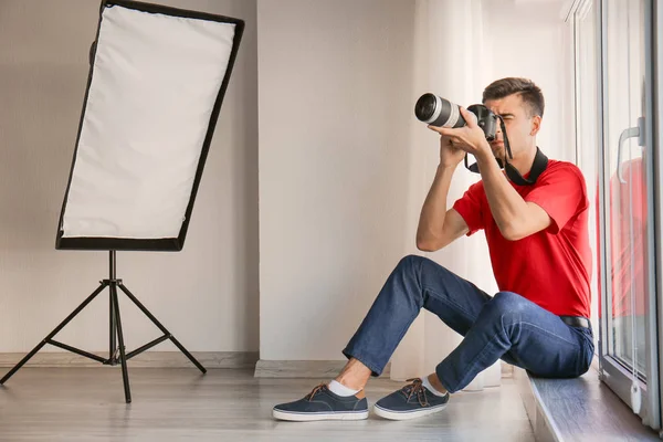 Fotograf sitzt auf Fensterbank im Atelier — Stockfoto