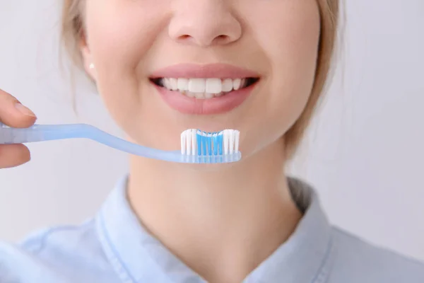 Woman with toothbrush on light background, closeup. Concept of dental hygiene — Stock Photo, Image