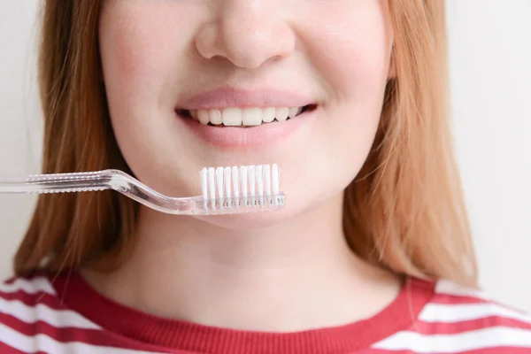 Frau mit Zahnbürste auf hellem Hintergrund, Nahaufnahme. Konzept der Zahnhygiene — Stockfoto