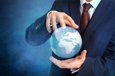 Karanlık arka planda dijital Dünya modeline sahip bir iş adamı