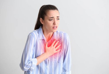 Işık arka plan üzerinde kalp krizi geçiren genç kadın