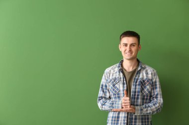 Renk arka planda işaret dilini kullanan genç sağır dilsiz adam
