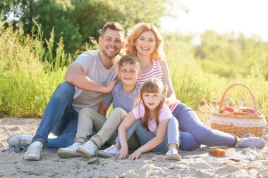 Nehir kenarında yaz pikniyerinde mutlu aile