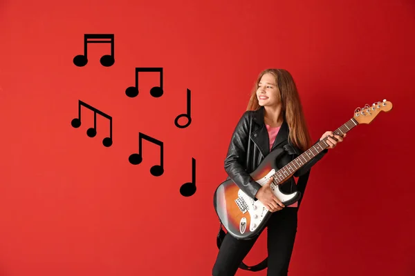 Дівчина-підліток грає на гітарі на кольоровому фоні — стокове фото
