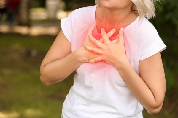 Dospělá žena trpící srdečním útokem venku, uzavřena — Stock fotografie