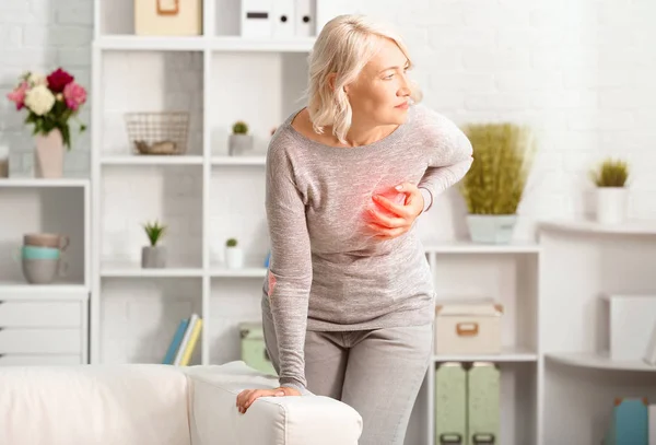 Mature woman suffering from heart attack at home — Stock Photo, Image