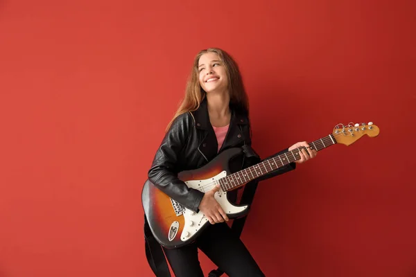 Teenage girl playing guitar against color background — Stock Photo, Image