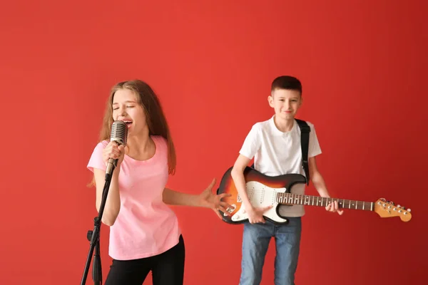 Malí hudebníci, co hrají proti barevnému pozadí — Stock fotografie