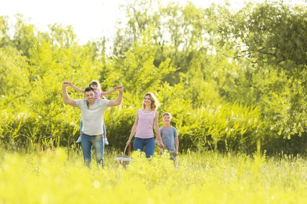 Familia feliz caminando en el parque en el día de verano —  Fotos de Stock