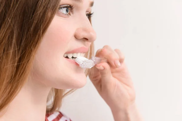 Γυναίκα με οδοντόβουρτσα σε ανοιχτόχρωμο φόντο, κοντινό. Έννοια της οδοντιατρικής υγιεινής — Φωτογραφία Αρχείου