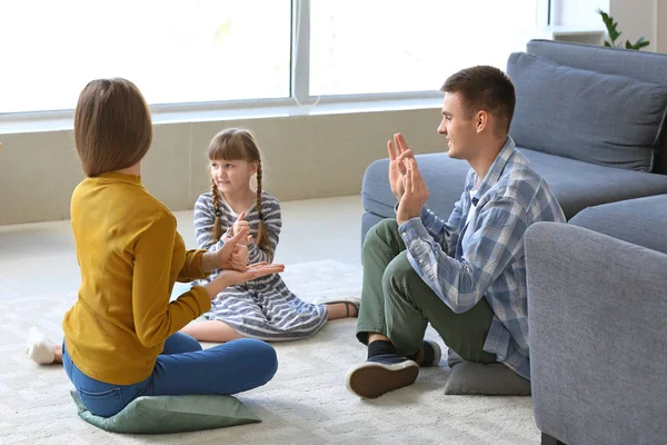 Familia muda sorda usando lenguaje de señas en casa — Foto de Stock