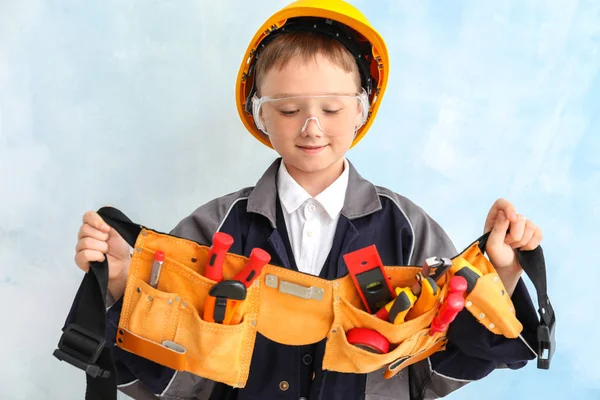 Lindo niño pequeño con herramientas cinturón en el fondo de color — Foto de Stock