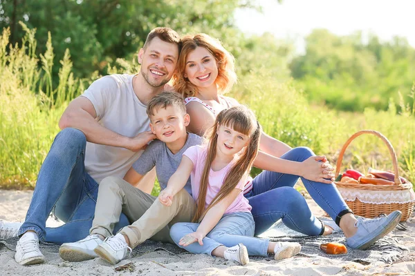 川の近くの夏のピクニックで幸せな家族 — ストック写真