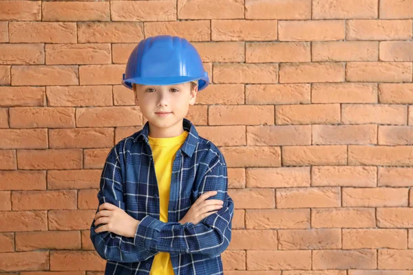 Lindo pequeño trabajador contra la pared de ladrillo — Foto de Stock