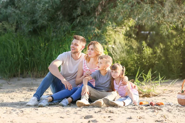 Happy family on summer picnic near river — Stock Photo, Image
