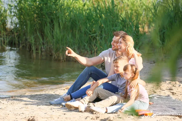 川の近くの夏のピクニックで幸せな家族 — ストック写真