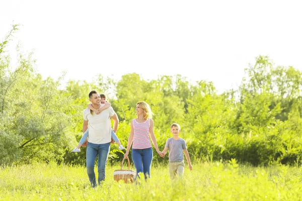 Счастливая семья гуляет в парке в летний день — стоковое фото