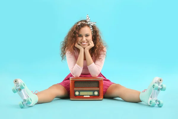 Schöne junge Frau auf Rollschuhen und mit Retro-Radioempfänger vor farbigem Hintergrund — Stockfoto