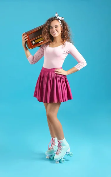 Beautiful young woman on roller skates and with retro radio receiver against color background — Stock Photo, Image