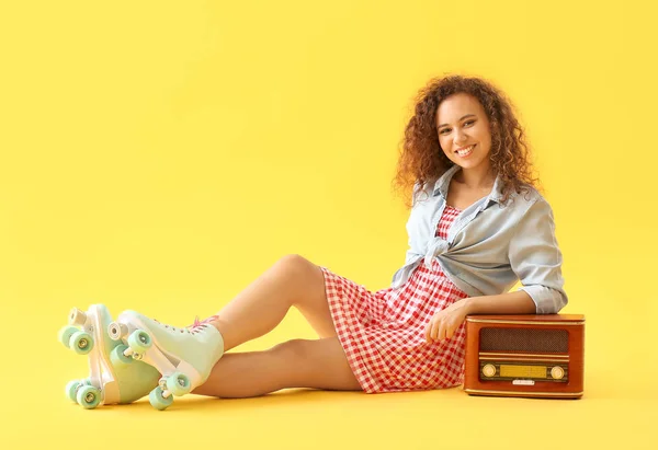 Hermosa mujer joven en patines y con receptor de radio retro contra fondo de color — Foto de Stock